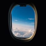 Utsikt fra et flyvindu over skyer og blå himmel