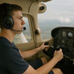 Pilot med headset styrer et småfly fra cockpiten